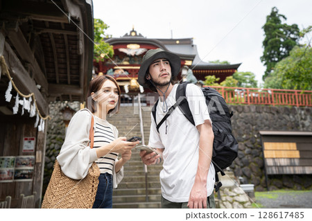 An inbound couple checking tourist information on their smartphones at a shrine An inbound couple checking tourist information on their smartphones at a shrine 128617485