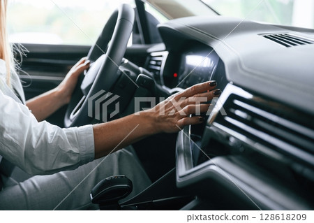 Close up view. Woman is sitting in a car and driving it 128618209