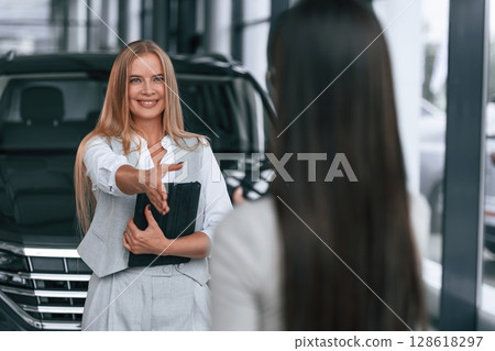 Female manager is helping woman customer in the car dealership salon 128618297