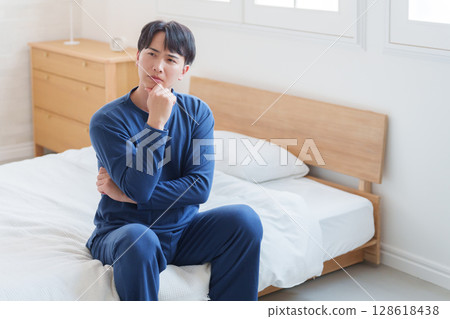 Man thinking in bed Man thinking in bed 128618438