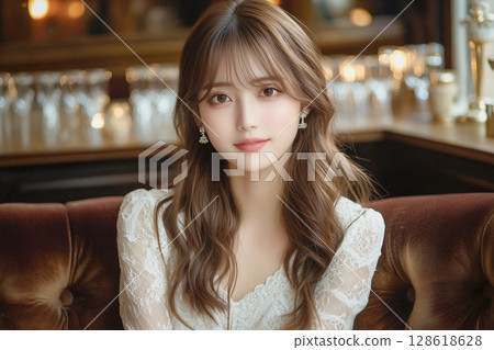 A young woman with beautiful wavy hair and earrings. Hostess. 128618628