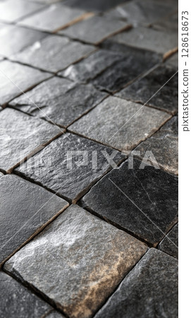 Close-up of black and gray cobblestone pavement with natural texture. 128618673