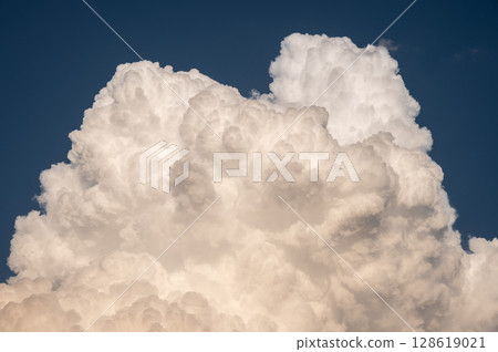 Cumulonimbus clouds appear on the sky. Cumulonimbus clouds almost always signal that there is a thunderstorm happening. 128619021