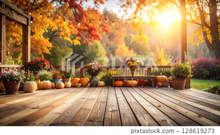 A wooden deck in autumn with the setting sun shining through and autumn leaves decorating it 128619273
