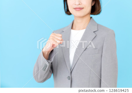 一位身穿西裝、揮拳的中年女商界女性 128619425