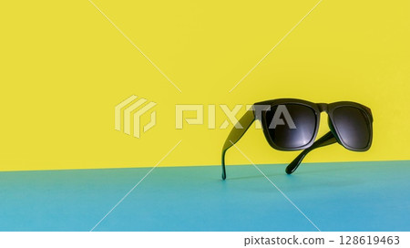 Suspended Sunglasses on Colorful Blue and Yellow Background 128619463