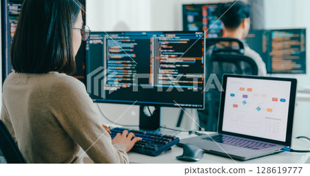 Closeup Adult Asia male, female freelance typing write prompt AI bot IT app smart program nomad, video game, terminal with coding language, user interface, designer, big data center desktop computer. 128619777