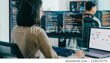 Closeup Adult Asia male, female freelance typing write prompt AI bot IT app smart program nomad, video game, terminal with coding language, user interface, designer, big data center desktop computer. 128619779