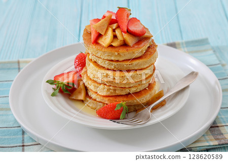 pancakes topped with apple slices and strawberries pancakes topped with apple slices and strawberries 128620589