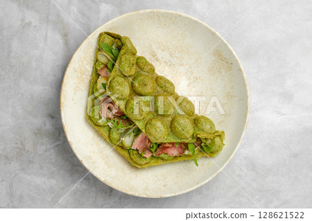 Unique green wrap filled with fresh ingredients served on a plate at a cozy cafe Unique green wrap filled with fresh ingredients served on a plate at a cozy cafe 128621522
