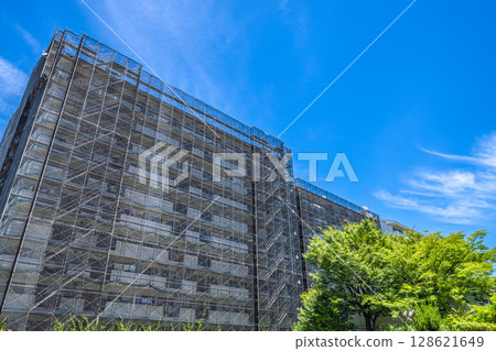 Yokohama cityscape in Japan. View of apartment building repairs and inspections, scaffolding and protective nets. Satellite antennas... Yokohama cityscape in Japan. View of apartment building repairs and inspections, scaffolding and protective nets. Satellite antennas... 128621649