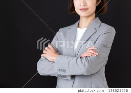 Middle-aged female business woman with arms crossed 128621936