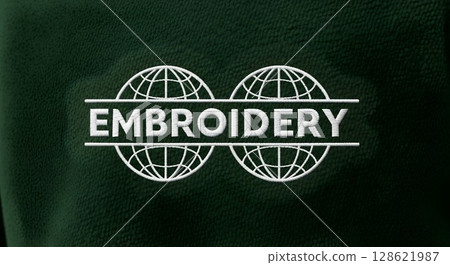 White embroidery text with abstract globes on dark green fabric. Textile customization showing craft and artistic detail. 128621987
