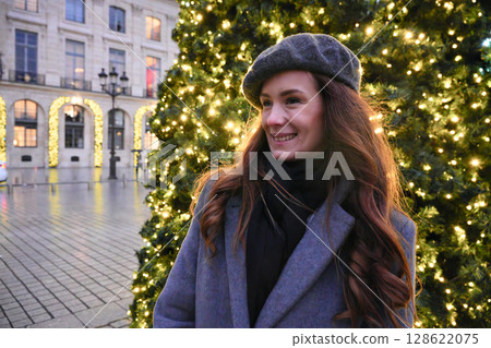 Smiling woman in Paris during Christmas holidays Smiling woman in Paris during Christmas holidays 128622075