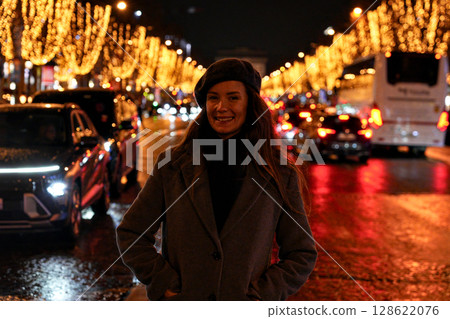 Smiling woman standing on festive illuminated street at night Smiling woman standing on festive illuminated street at night 128622076