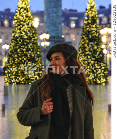 Smiling woman at Christmas lights in Paris square Smiling woman at Christmas lights in Paris square 128622139