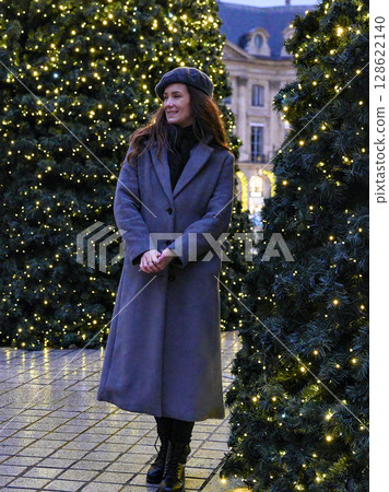 Woman standing among Christmas trees in Paris street Woman standing among Christmas trees in Paris street 128622140