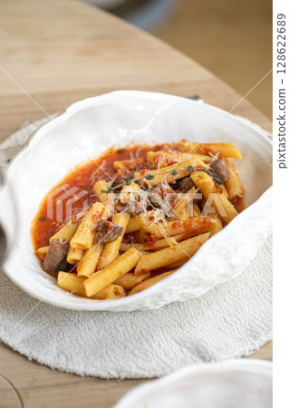 Penne pasta with veal tomato sauce and pecorino cheese Penne pasta with veal tomato sauce and pecorino cheese 128622689