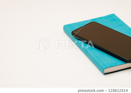 一部智慧型手機和一本藍色筆記本的簡單組合 128622814