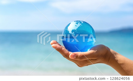 AI 圖片：一隻手握著玻璃球，背景是海洋 128624056