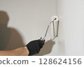 Roller painting of the wall, working painting on the surface, painting the walls in the apartment, repair with white paint. With space to copy. High quality photo 128624156