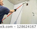 Roller painting of the wall in the color of hakka. Apartment painting, renovation. There is a place to copy. High quality photo 128624167