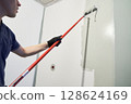 A professional paints the inside wall of his house. Apartment renovation. Concrete walls are painted gray with a paint roller. High quality photo 128624169