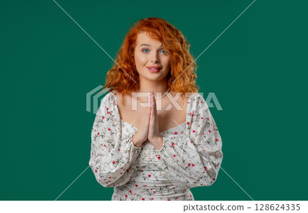 Ginger-haired woman praying with palms in sincere silent request. Hope, faith 128624335