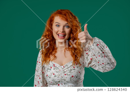 Happy woman gives thumbs up LIKE gesture with excitement and expressive approval 128624340