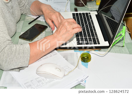 A woman is working on a laptop. A woman is working on a laptop. 128624572
