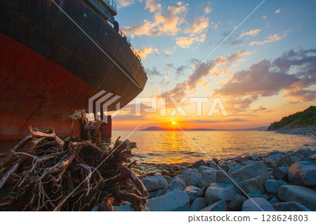 Stranded ship after a storm at sunset Stranded ship after a storm at sunset 128624803