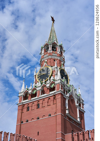Moscow Kremlin Spasskaya Tower with Historic Clock Faces and Red Star Finial against a Cloud-Scattered Sky Moscow Kremlin Spasskaya Tower with Historic Clock Faces and Red Star Finial against a Cloud-Scattered Sky 128624956