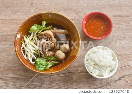 boiled braised beef meat and tendon couple organ in herb brown soup on bowl dipping spicy chili sauce eat couple with plain rice boiled braised beef meat and tendon couple organ in herb brown soup on bowl dipping spicy chili sauce eat couple with plain rice 128627048
