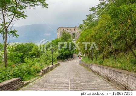 old stone road reaching the Gjirokaster castle in Albania 128627295