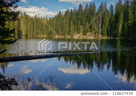 sunset reflects over surface of Zminje lake in Durmitor National Park, Zabljak, Montenegro 128627439