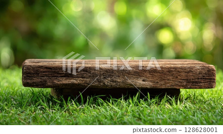 Clean white and wooden product display platforms on vibrant green grass in natural sunlight. 128628001