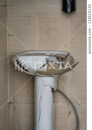broken washbasin of an outdoor toilet broken washbasin of an outdoor toilet 128628130