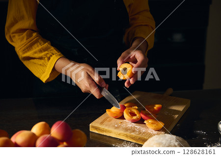 Chef Preparing Apricots in a Rustic Kitchen Setting for Baking or Cooking Fresh Dishes Chef Preparing Apricots in a Rustic Kitchen Setting for Baking or Cooking Fresh Dishes 128628161