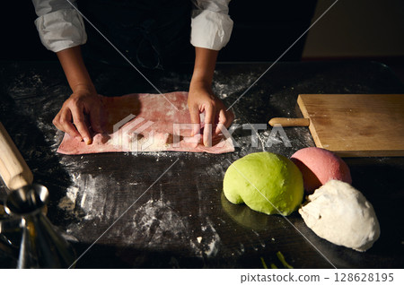 Homemade Ravioli Preparation with Vibrant Colorful Pasta Rolls on Black Surface Homemade Ravioli Preparation with Vibrant Colorful Pasta Rolls on Black Surface 128628195