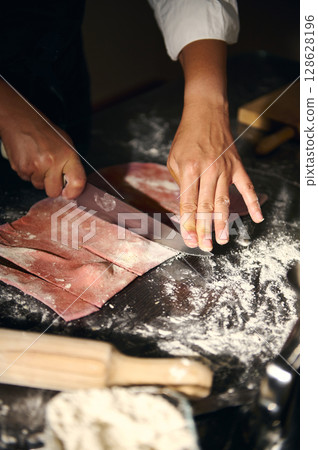 Chef Preparing Handmade Pink Pasta Dough for Traditional Italian Dishes 128628196