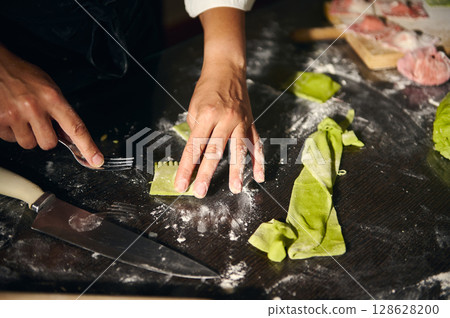 Chef Crafting Green Ravioli with Fork, Celebrating Italian Gastronomy 128628200