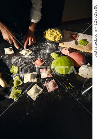 Woman Preparing Colorful Ravioli with Traditional Italian Technique in a Kitchen Setting Woman Preparing Colorful Ravioli with Traditional Italian Technique in a Kitchen Setting 128628206