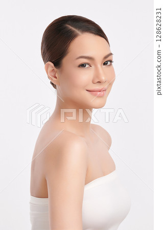 A beautiful young Asian woman with clean, fresh skin against a white background. Skincare, facial treatment, cosmetology, beauty, and spa. An elegant portrait of an Asian woman. 128628231