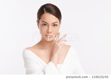 A beautiful young Asian woman with clean, fresh skin against a white background. Skincare, facial treatment, cosmetology, beauty, and spa. An elegant portrait of an Asian woman. 128628240