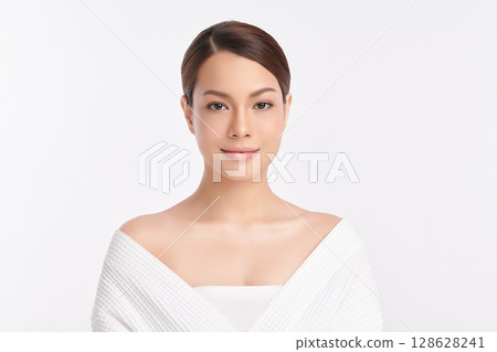 A beautiful young Asian woman with clean, fresh skin against a white background. Skincare, facial treatment, cosmetology, beauty, and spa. An elegant portrait of an Asian woman. 128628241