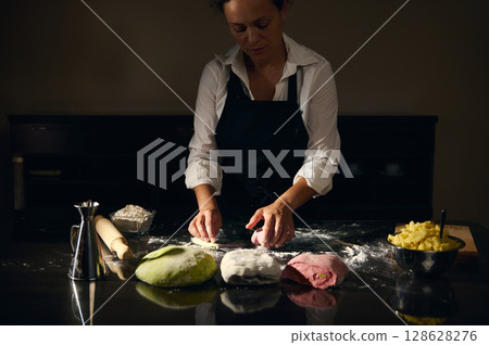 Chef Preparing Italian Pasta Dough in Traditional Flag Colors in a Cozy Kitchen Environment Chef Preparing Italian Pasta Dough in Traditional Flag Colors in a Cozy Kitchen Environment 128628276