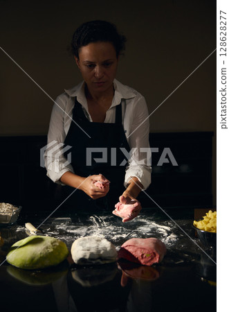 Chef Preparing Colorful Pasta Dough Representing the Italian Flag in a Kitchen Setting 128628277