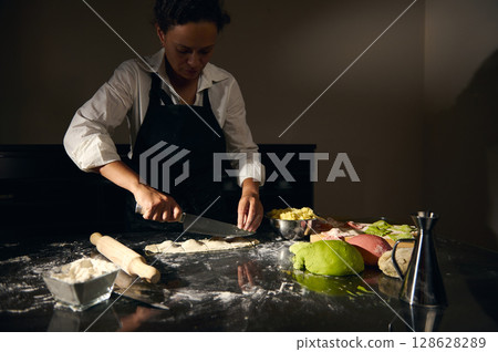 Woman Chef Preparing Homemade Ravioli Pasta Using Colorful Dough in Traditional Italian Style 128628289
