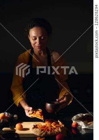 Woman Prepares Homemade Fruit Tart in a Cozy Kitchen Setting Woman Prepares Homemade Fruit Tart in a Cozy Kitchen Setting 128628294