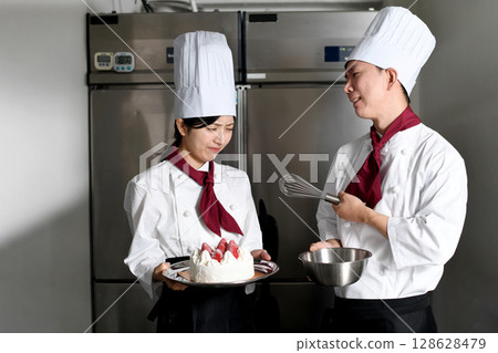 一位男糕點師對一位拿著蛋糕的女士生氣 一位男糕點師對一位拿著蛋糕的女士生氣 128628479